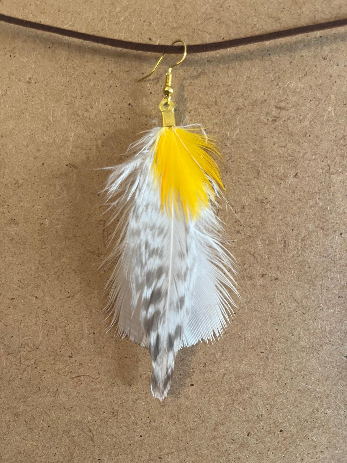 Pendiente artesanal Luz y Presencia con plumas blancas moteadas y pluma amarilla en composición ligera y luminosa